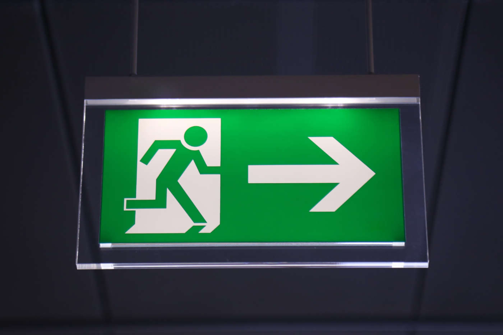 Emergency exit sign above a black door
