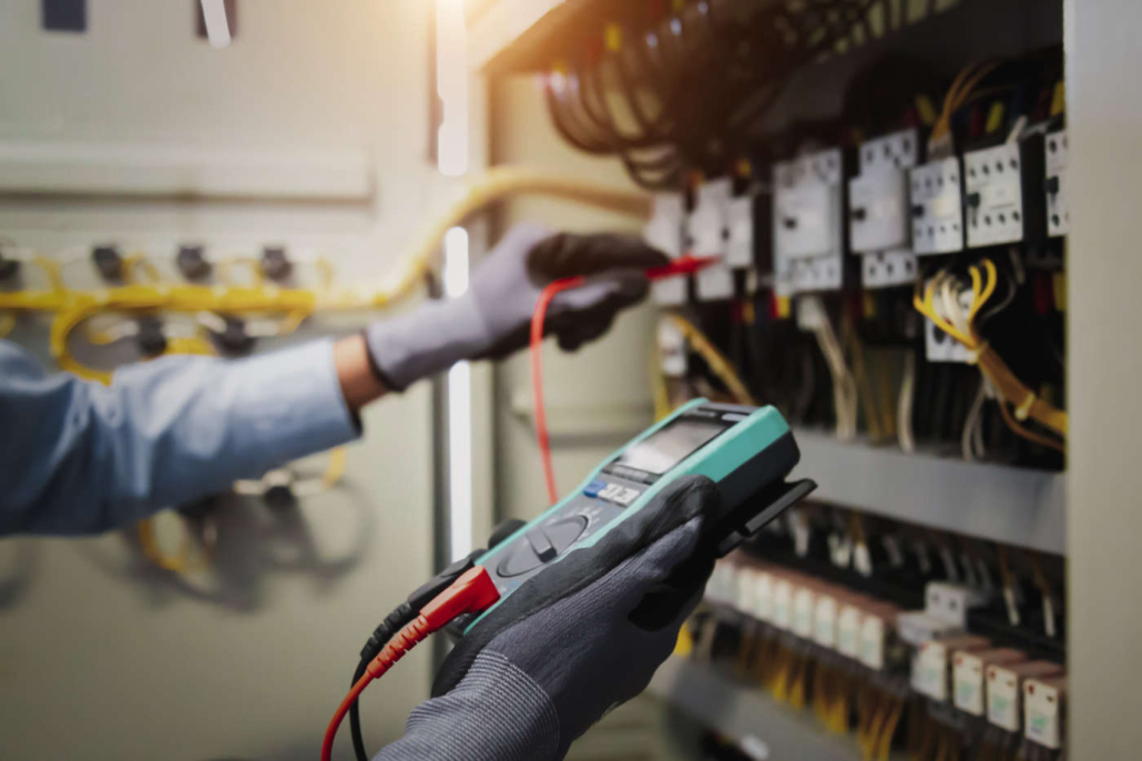 Elektrizität und elektrische Wartung, Ingenieur Hand halten AC-Multimeter Überprüfung der elektrischen Stromspannung an Leistungsschalterklemme und Kabelverdrahtung Hauptstromverteilung.